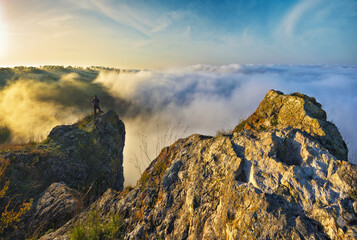 woman stands on a rock above a river canyon. female tourist enjoys foggy autumn landscape. nature of Ukraine