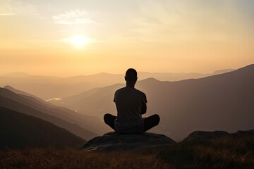 Fototapeta premium Rear view of man practicing meditation or yoga pose on the mountain at sunset time. Generative ai.
