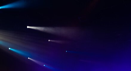 Beams of scenic spot lights in smoke over dark background,