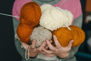 Woman's hands holding colored balls of yarn for knitting. Selection of colorful yarn wool. The concept of knitting, buying wool, handmade, hobby