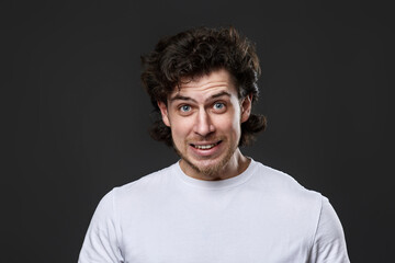 young bearded man in casual white t-shirt looking at the camera