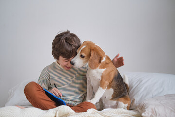 Incredibly sweet photo of a cute little boy hugging his beagle with eyes closed, loving bond with...