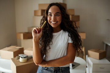Young Asian female business owner online prepare parcel boxes for customers to call and talk to...