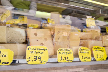 View of cheeses inside a fridge with price sign at a street market; Piove di Sacco, Veneto, Italy - obrazy, fototapety, plakaty