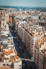 Obraz premium Vertical shot of a street surrounded by beautiful buildings on a sunny day in Madrid, Spain