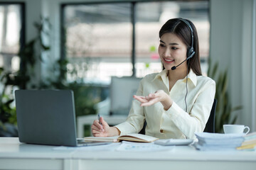 close up call center operator in wireless headset talking with customer, woman in headphones with microphone consulting client on phone in customer support service, looking at computer screen.