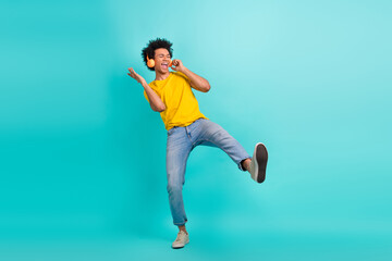Fototapeta na wymiar Full size portrait of cheerful excited person enjoy listen favorite music dancing isolated on turquoise color background