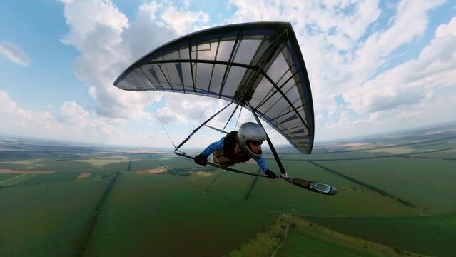 Girl hang glider pilot flies in the air with other pilots