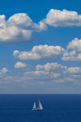 Sailboat on blue sky and white clouds