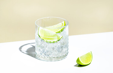 Ti punch alcoholic cocktail drink with white rum agricole, sugar syrup and lime, traditional Caribbean beverage. Beige background, minimalist style