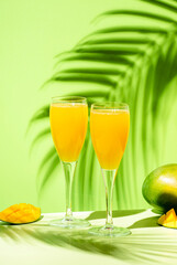 Mango bellini alcoholic cocktail drink with prosecco or champagne, mango puree, syrup and ice....