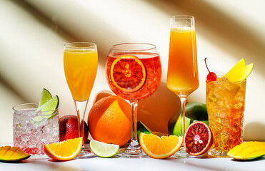 Summer fruit and citrus cocktails for party, low alcohol refreshing drinks with wine, champagne and rum. Beige background, hard light, shadow pattern