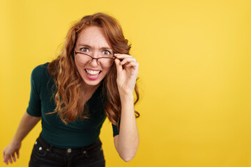 Redheaded woman with glasses looking at the camera with surprise