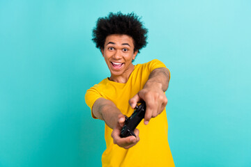 Portrait of overjoyed positive young man hold gamepad have fun playing games isolated on aquamarine...