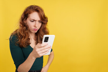 Worried redheaded woman using a mobile phone