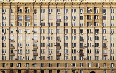 Urban residential stalinist building wall with lot of windows front view close up