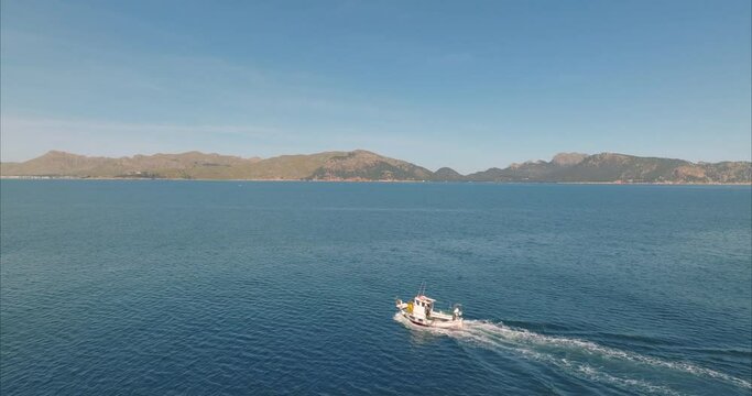 Barco con pescador pescando con casas de fondo, mediterr&aacute;neo (Dji Mavic 3 cine)