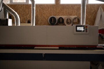 Single sided automatic edge banders on furniture factory, close up. edge banding machine making...