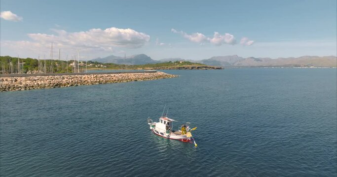 Barco con pescador pescando con casas de fondo, mediterr&aacute;neo (Dji Mavic 3 cine)