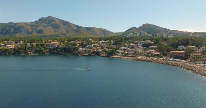 Barco con pescador pescando con casas de fondo, mediterr&aacute;neo (Dji Mavic 3 cine)