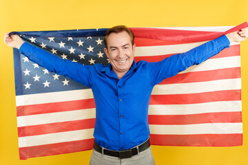 Happy mature man raising a north america national flag