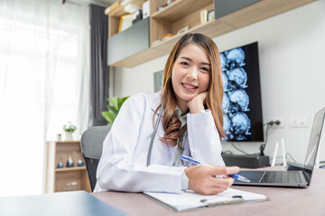 A beautiful Asian doctor in Thailand discusses the condition of a patient undergoing treatment in a doctor's clinic.