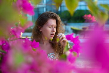 Portrait of beautiful young allergic woman is suffering from pollen allergy or cold on natural...