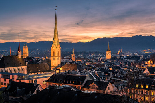 Panorama of Z&uuml;rich city center with roofs of houses and churches during sunset