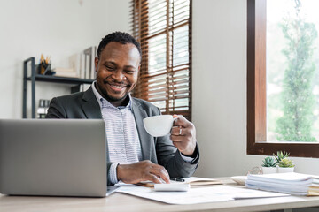 Success at work, good deal. African-American guy looks at the laptop screen, screams excitedly and raises his fists in a victory gesture at home