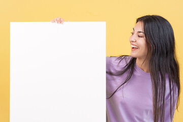 Happy caucasian woman looking at a blank panel