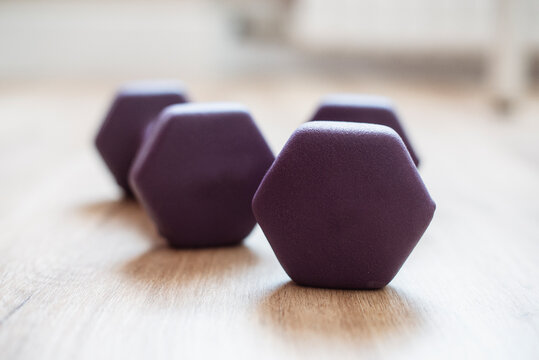 Close-up of two purple dumbbells on the floor