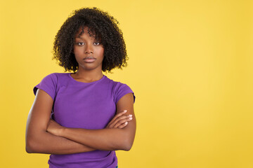 Angry woman with afro hair posing with arms crossed