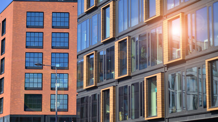Obraz premium A modern corporate building in the city. The blue sky is reflected in the buildings large glass windows. Glass facade.