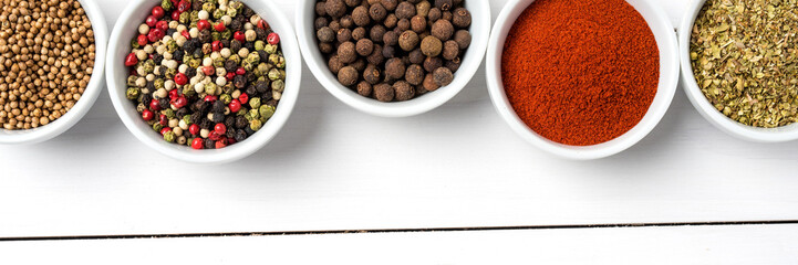 Herbs and spices in white bowls. Food background