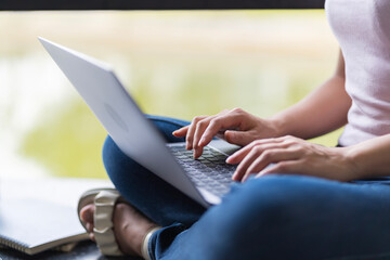 Asian female student Studying for exams in the area of the university. Communicate via mobile phone or laptop connected to the Internet. with many sources of knowledge