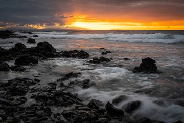 Long exposure shot of a sunrise over the rocky beach in Oahu, Hawaii.