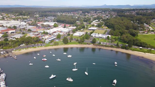 Aerial drone pullback reverse view of Ulladulla in the City of Shoalhaven, NSW, Australia, showing Ulladulla Harbour 