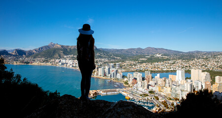 silhouette of woman looking at panoramic view of Calpe city in Spain