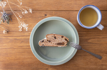 Dried flowers and tea on a wooden table, baked goods on a khaki round plate