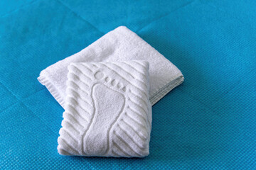 A stack Clean white bath towels lying on bed in hotel suite