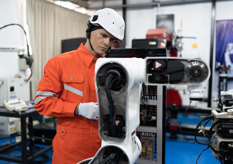 Caucasian technician engineer man with checking machine arm robot at factory	