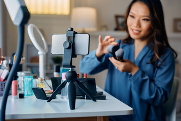 Close up of makeup artist recording beauty vlog at home.