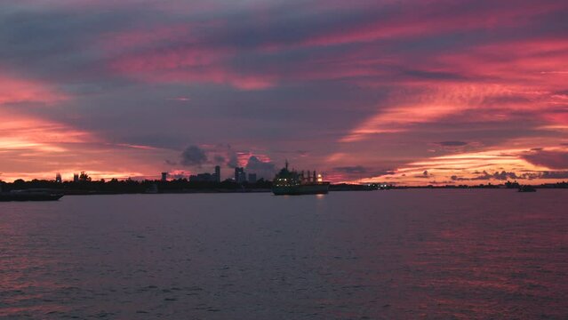 Mississippi River with boats by the coasts under a scenic pink sunset sky