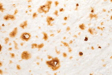 Pita bread tortilla handmade in tandoor, baked specks, closeup structure, background wallpaper, uniform texture pattern