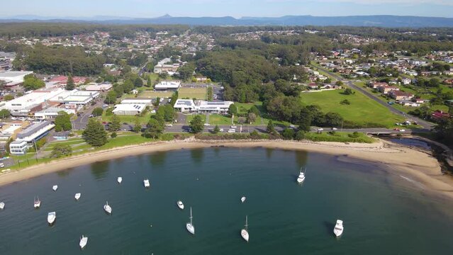 Aerial drone pullback reverse view of Ulladulla in the City of Shoalhaven, NSW, Australia, showing Ulladulla Harbour 