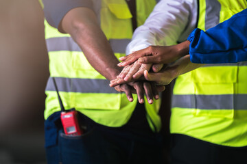 Warehouse worker joint hand together to making teamwork, Cooperation in factory with engineers and technician stacking hands to work together on big industrial project.