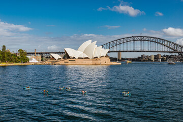 Sydney opera house and harbour bridge. And kayakers in the sea.