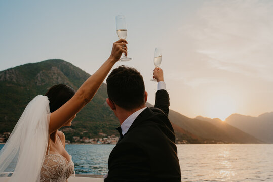 bride and groom newlyweds drinking champagne wine on boat on wedding day sunset romantic boho 