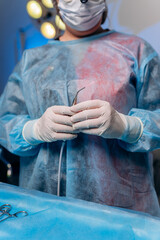 Close up of professional surgeon proctologist before operation holding an anoscope in the operating...