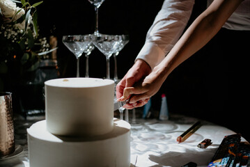 Fototapeta na wymiar Champagne tower for newlyweds on their wedding day cutting cake drinking wine 